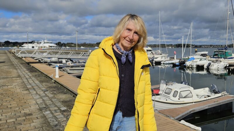 Françoise Sylvestre souriante devant le port de l'Île-aux-Moines